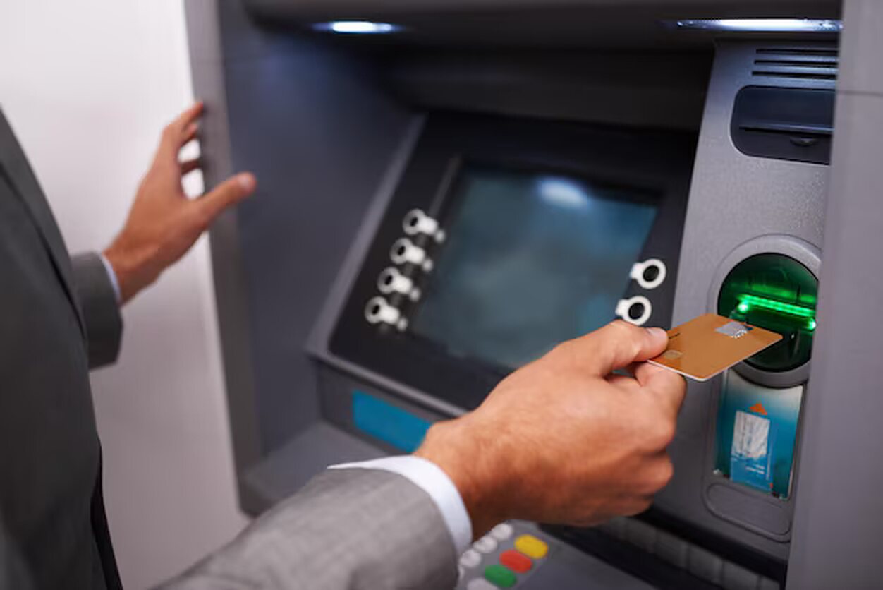 A person using a bank card at an ATM